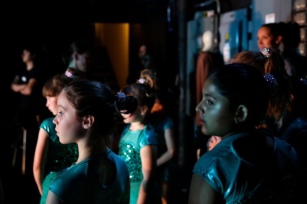 Young dancers watch the performance from backstage